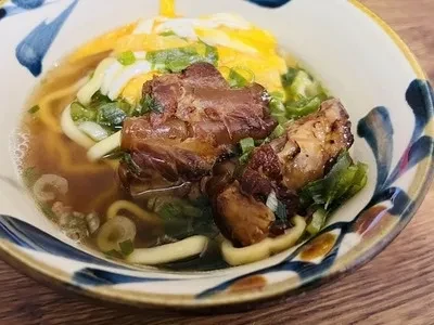 沖縄そば沖縄そばは、沖縄の麺料理であり、中華そばに似た麺が使われています。豚の角煮や紅しょうがトッピングされ、特有のだしで味わい深い一杯です。